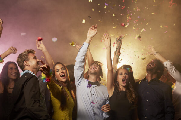 Excited young friends screaming while enjoying on dance floor at nightclub